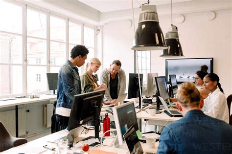 Creative business people working on computers in open plan office stock photo