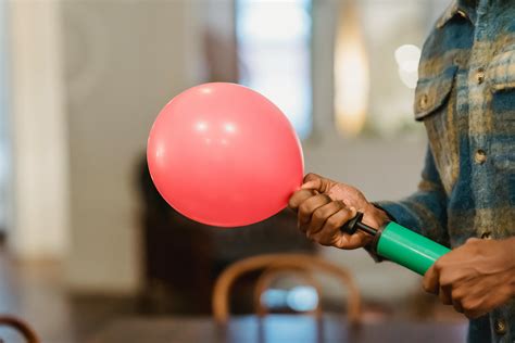 Black man inflating balloon with pump · Free Stock Photo