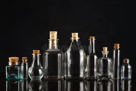 Glass Bottles of Different Shapes and Sizes on a Black Background Stock ...