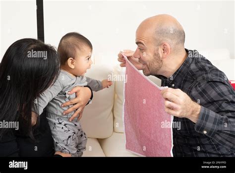 Six month old baby boy peek a boo game with father and mother Stock Photo - Alamy