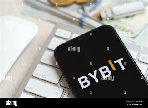 KYIV, UKRAINE - MARCH 15, 2024 Bybit logo on iPhone display screen on white keyboard with money ...