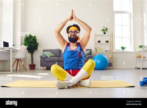 Funny man sitting in easy yoga pose with arms raised, learning to do ...