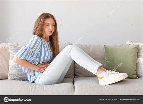 Young Woman Appendicitis Sitting Sofa Home Stock Photo by ©serezniy 652197516