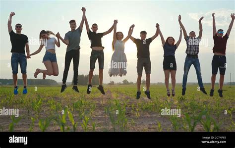 Happy friends jumping holding hands at sunset Stock Photo - Alamy