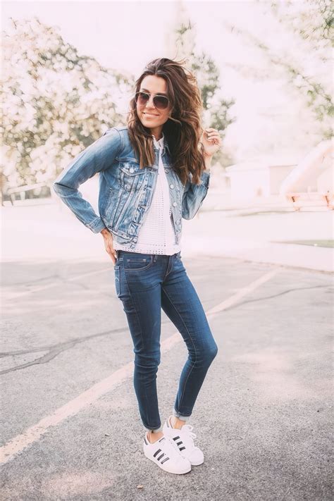 Picture Of a denim jacket with a white top, denim skinnies and white trainers