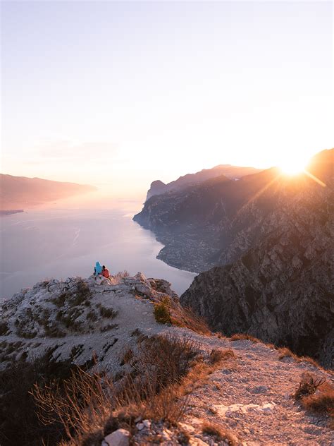 People Sitting on Cliff Edge during Sunset · Free Stock Photo