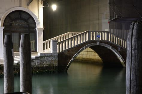 Premium Photo | Arch bridge over river at night