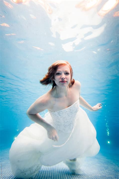 "Trash The Dress Underwater Bride Swimming In Wedding Dress Facing Camera" by Stocksy ...