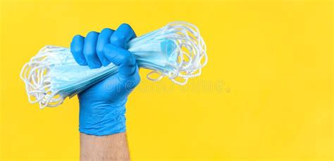 Hand in Medical Latex Gloves Holding Heap of Face Protective Masks. Protection Against ...