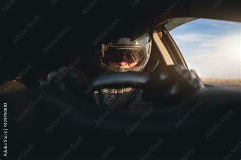 Rally racer in a helmet is driving a car concept. Stock Photo | Adobe Stock