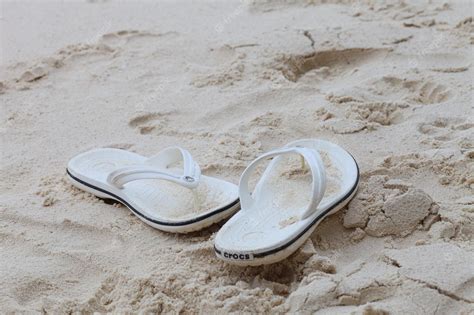 Premium Photo | White flip flops on the beach