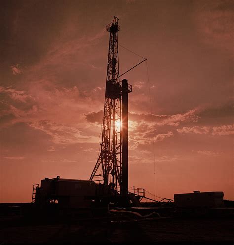 Oil rig at sunset. Photograph by Paul Chauncey