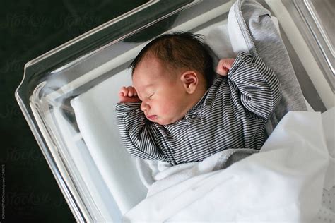 "Newborn Baby Boy Sleeping In A Hospital Room." by Stocksy Contributor "BONNINSTUDIO " - Stocksy