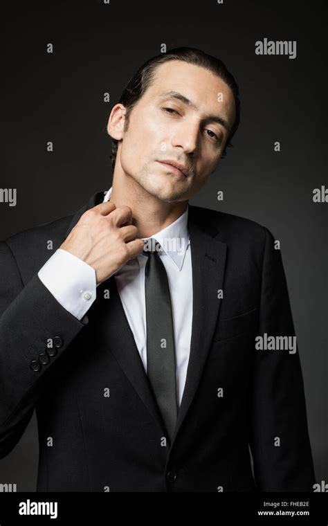 portrait of an attractive mysterious man in black suit and tie on dark background Stock Photo ...