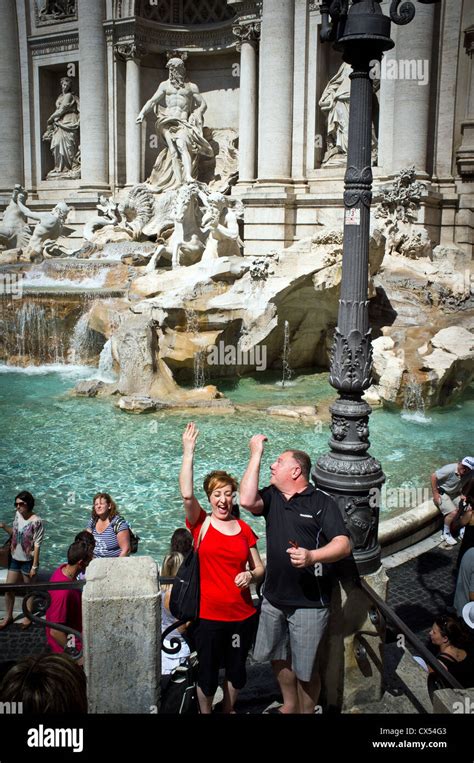 Couple throwing coins into Trevi Fountain, Rome, Italy Stock Photo - Alamy