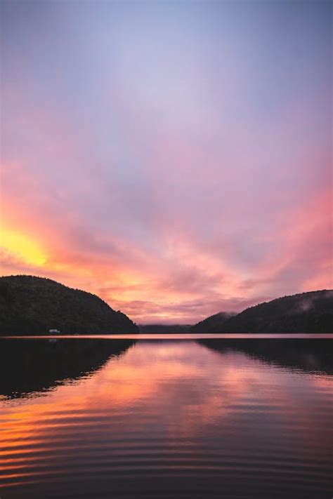 Calm Lake near Mountains during Sunset · Free Stock Photo