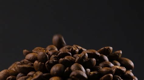 Slow motion of roasted coffee beans falling. Organic coffee seeds. 10192663 Stock Video at Vecteezy