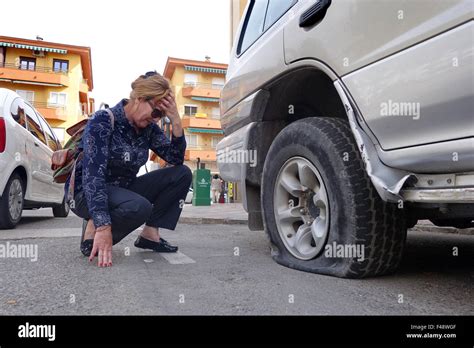 Woman female driver motorist with flat punctured car tyre puncture Stock Photo - Alamy