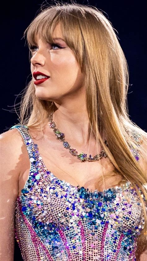 taylor swift wearing a colorful dress and red lipstick