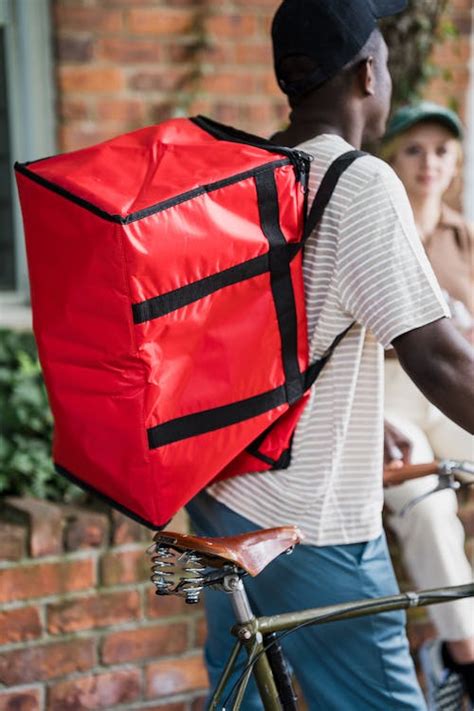 Close-up of Courier with Backpack on Bike · Free Stock Photo