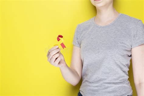 World Hepatitis Day Concept. Girl in Gray T-shirt Holds in Her Hand Awareness Symbol Red-yellow ...