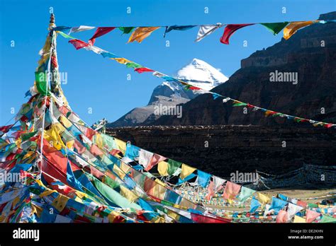 Tibetan Buddhism, Tarboche, a flagpole with colourful prayer flags, in front of the snow-covered ...