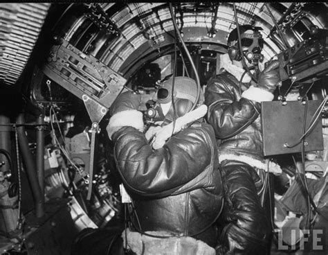 Interior of a B-17 Flying Fortress. Waist gunners, clad in hi-altitude sheepskin clothing ...