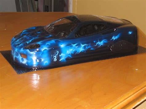 a cake shaped like a car on top of a wooden table with blue flames coming out of it