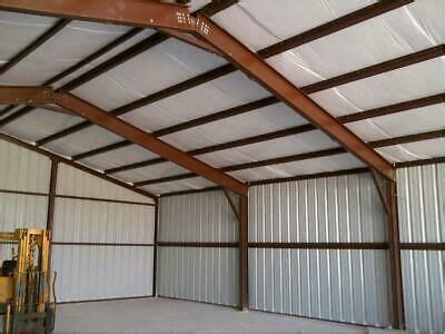 the inside of a large metal building with lots of windows and doors on each side