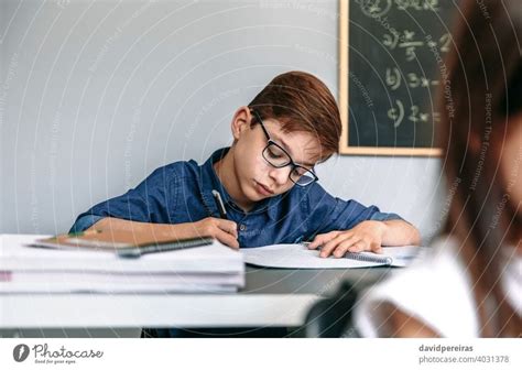 Boy writing in notebook at school - a Royalty Free Stock Photo from Photocase