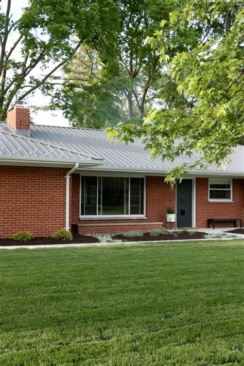 brick house with green metal roof - Gita Layton