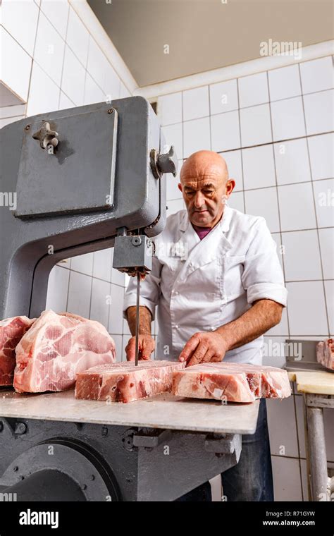 Butcher cutting meat with bandsaw in butchery Stock Photo - Alamy