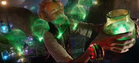 a man holding a glowing jar with green lights on it's face and hands