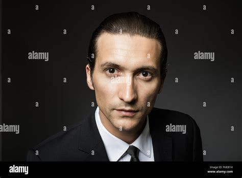 portrait of an attractive mysterious man in black suit and tie on dark background Stock Photo ...