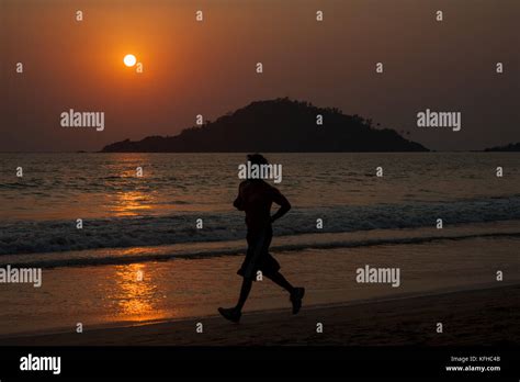 Running on the beach at sunset Stock Photo - Alamy