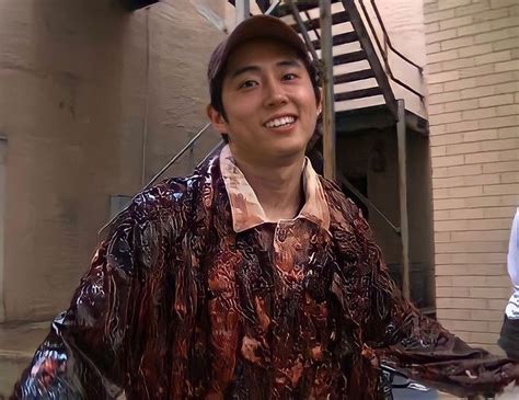 a man standing in front of a building next to a fire hydrant and stairs