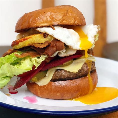 A shot of our classic Aussie Burger with the lot - Toasted burger bun with beef patty, beetroot ...