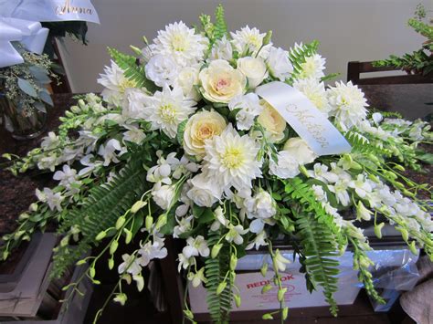 Shades of white flowers for the casket include orchids, kale, dahlias ...