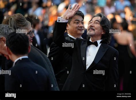 Koji Yakusho, right, poses for photographers upon arrival at the awards ceremony during the 76th ...