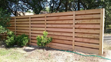 a wooden fence in front of some trees