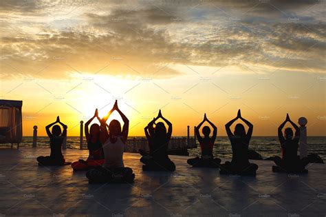 Group women doing yoga at sunrise featuring background, balance, and beach | How to do yoga ...