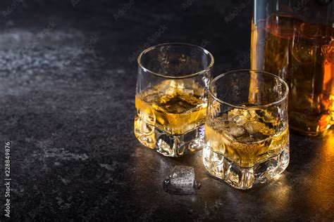 Whiskey with ice in glasses and bottle Stock Photo | Adobe Stock