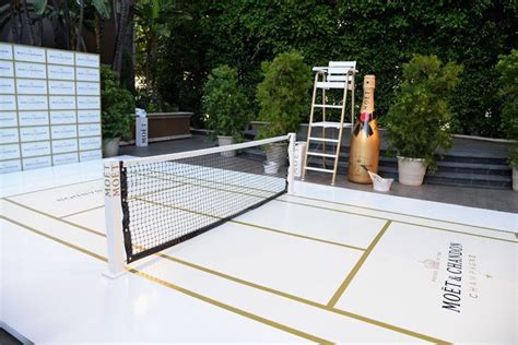 A giant prop bottle of champagne stood by the mini tennis court. | Tennis court, Tennis events ...