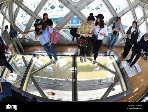 Tourists take pictures inside the tower bridge in London, England, 20 August 2017. The glass ...