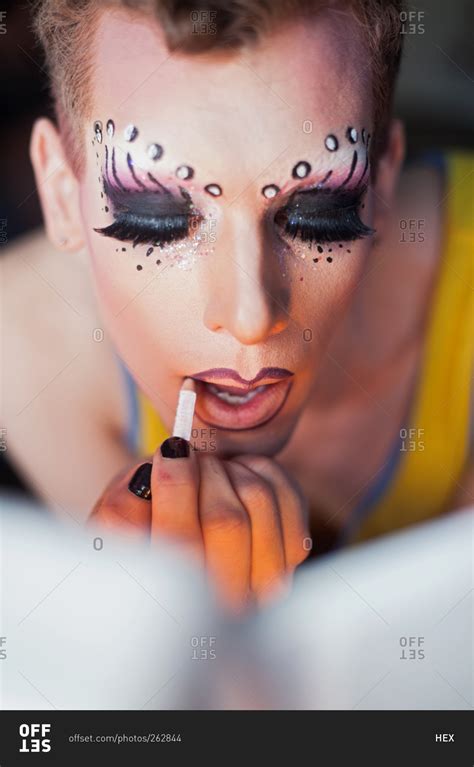 Man applying drag queen cosmetics stock photo - OFFSET