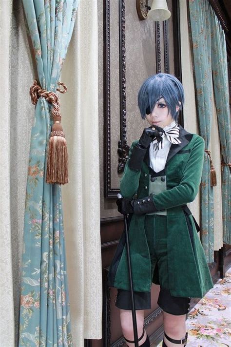 a woman dressed in green and black standing next to a mirror with her ...