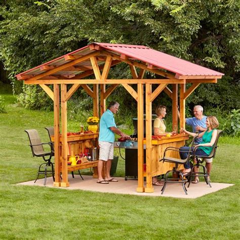 a group of people sitting around a wooden gazebo on top of a lush green ...