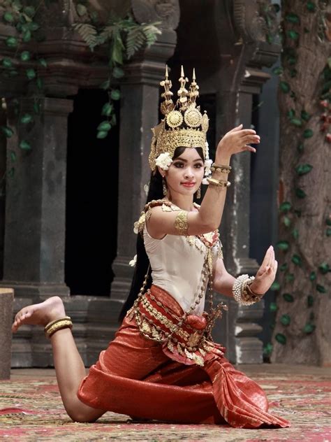 a woman dressed in traditional thai garb and holding her hand out to the side