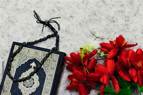 Holy Quran with Arabic calligraphy meaning of Al Quran and black rosary ...