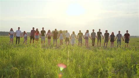 Happy Friends Jumping Holding Hands at Sunset. Stock Footage - Video of ...